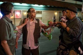 Tony Gardner (L) and Hugo Villasenor (R) apply final touches to John Kreng's zombie make up in THE SCOUT'S GUIDE TO THE 