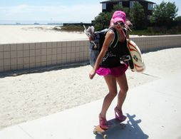 Sabrina Parisi in Long Beach skateboarding in high heels and holding a Kite, harness and a Kite-board