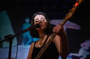 Mavis playing with her band (plays bass and lead vocals)